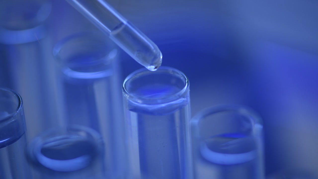 Primo piano di liquido che viene versato in una provetta in un laboratorio