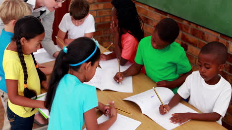 Teacher-helping-her-pupils-during-class