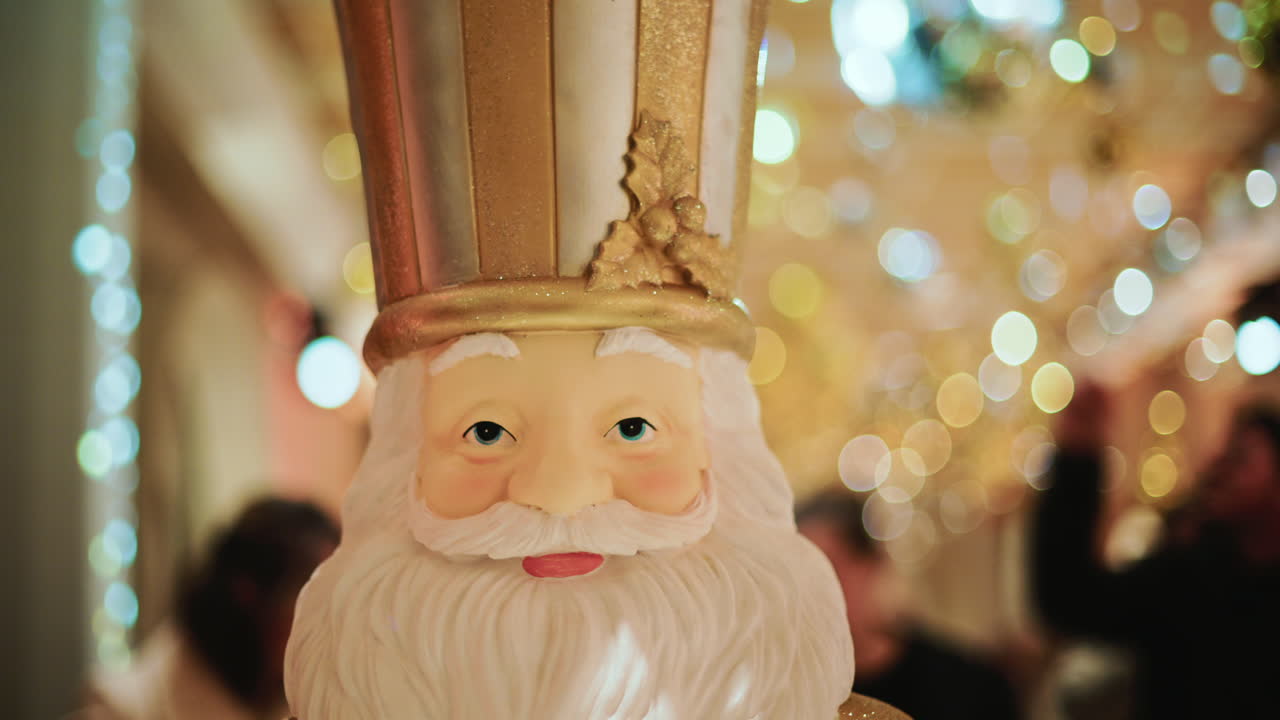 Close up of a Santa Claus figure inside a festive Christmas installation with warm lights and ornaments