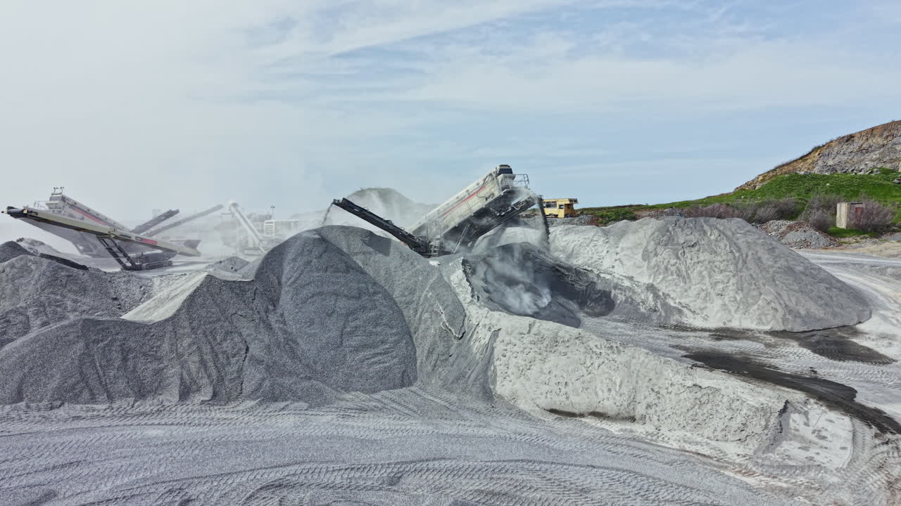 Een granietgroeve toont machines die steen verwerken en grote stapels graniet creëren op een groeve.