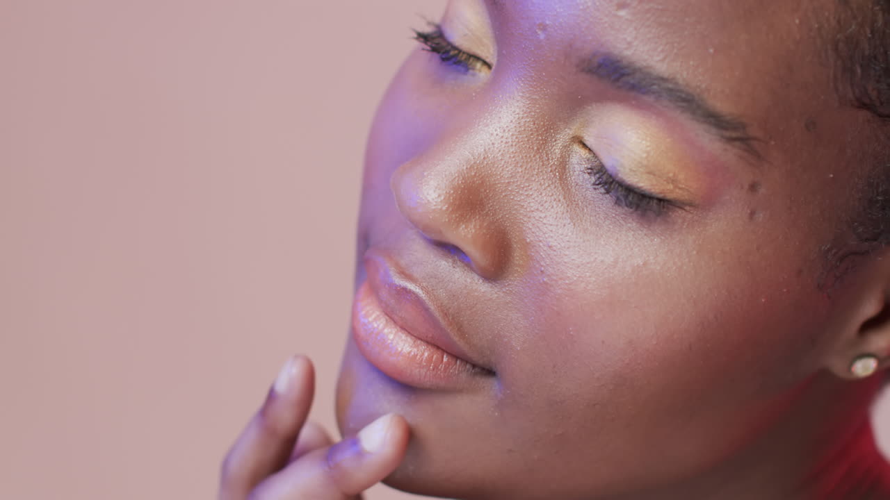 Afroamerikanische Frau mit kurzem dunklem Haar in blauem und rosa Licht mit Textfreiraum, Zeitlupe.