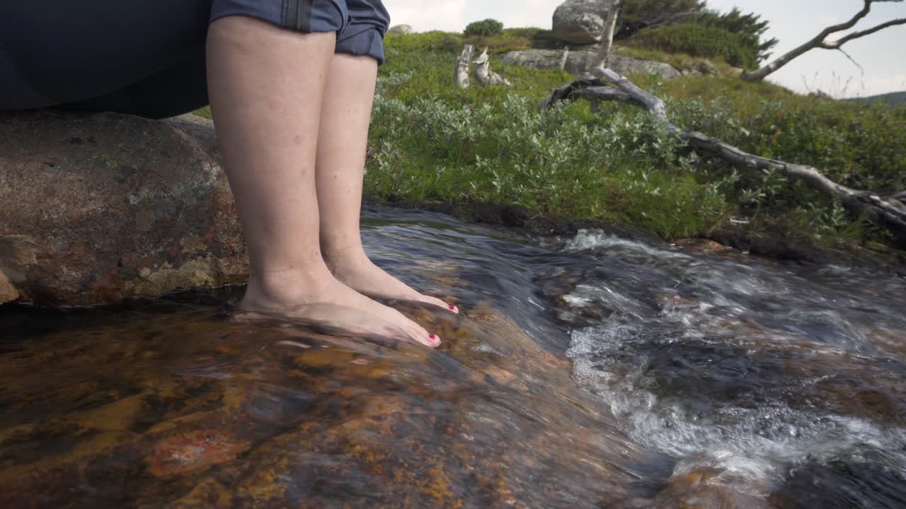 차가운 신선한 시내 물에서 여성 등산객 냉각 및 청소 발