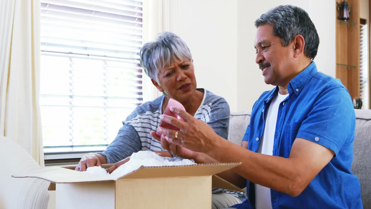 pareja de alto nivel mirando el cuenco en la sala de estar 4k