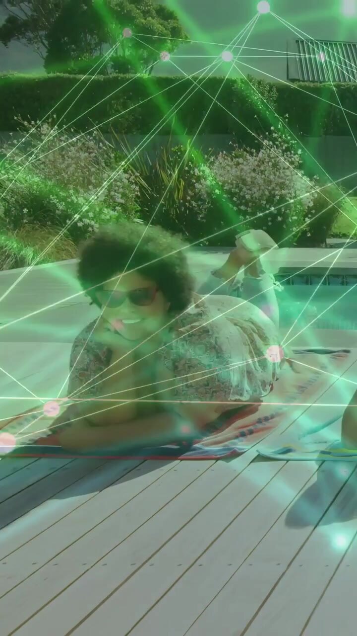 Video verticale: Donna sdraiata su un asciugamano, la telecamera riprende mentre sorride, con un'animazione in sovrapposizione per annunci pubblicitari.