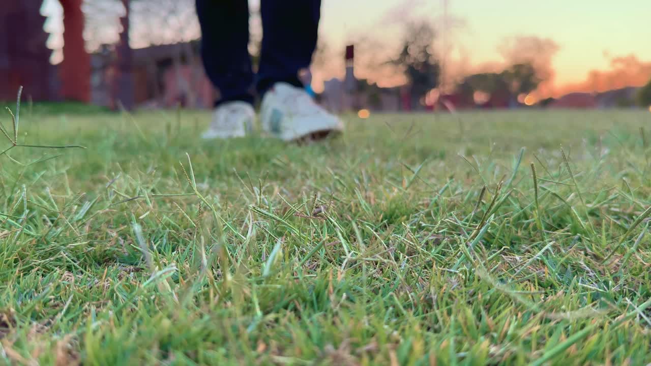 closeup of a man walking toward camera on the grass lawn at home garden