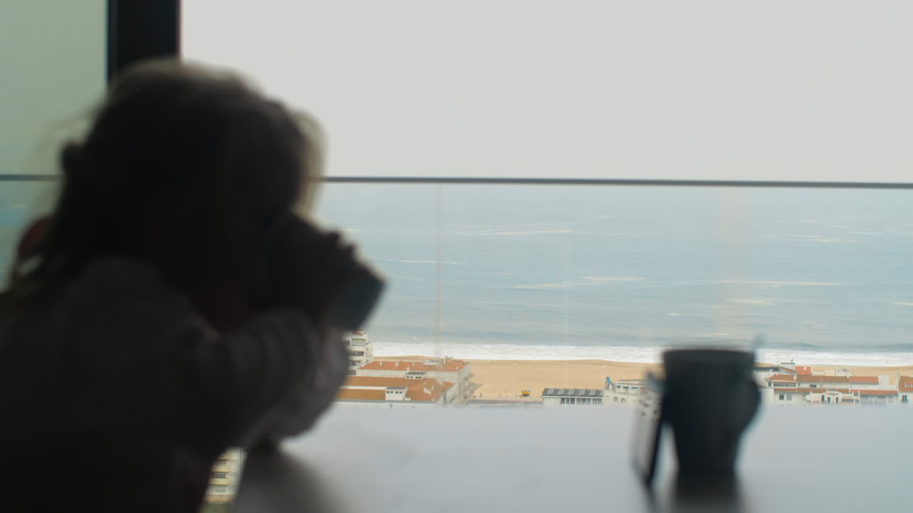Girl having breakfast with cartoons against ocean scene outside