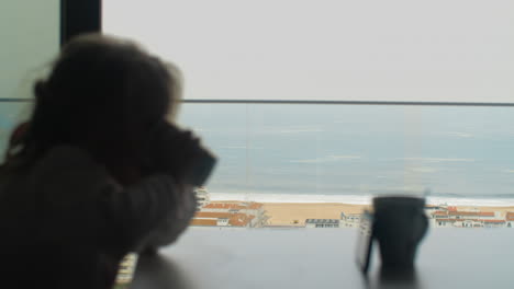 Girl-having-breakfast-with-cartoons-against-ocean-scene-outside