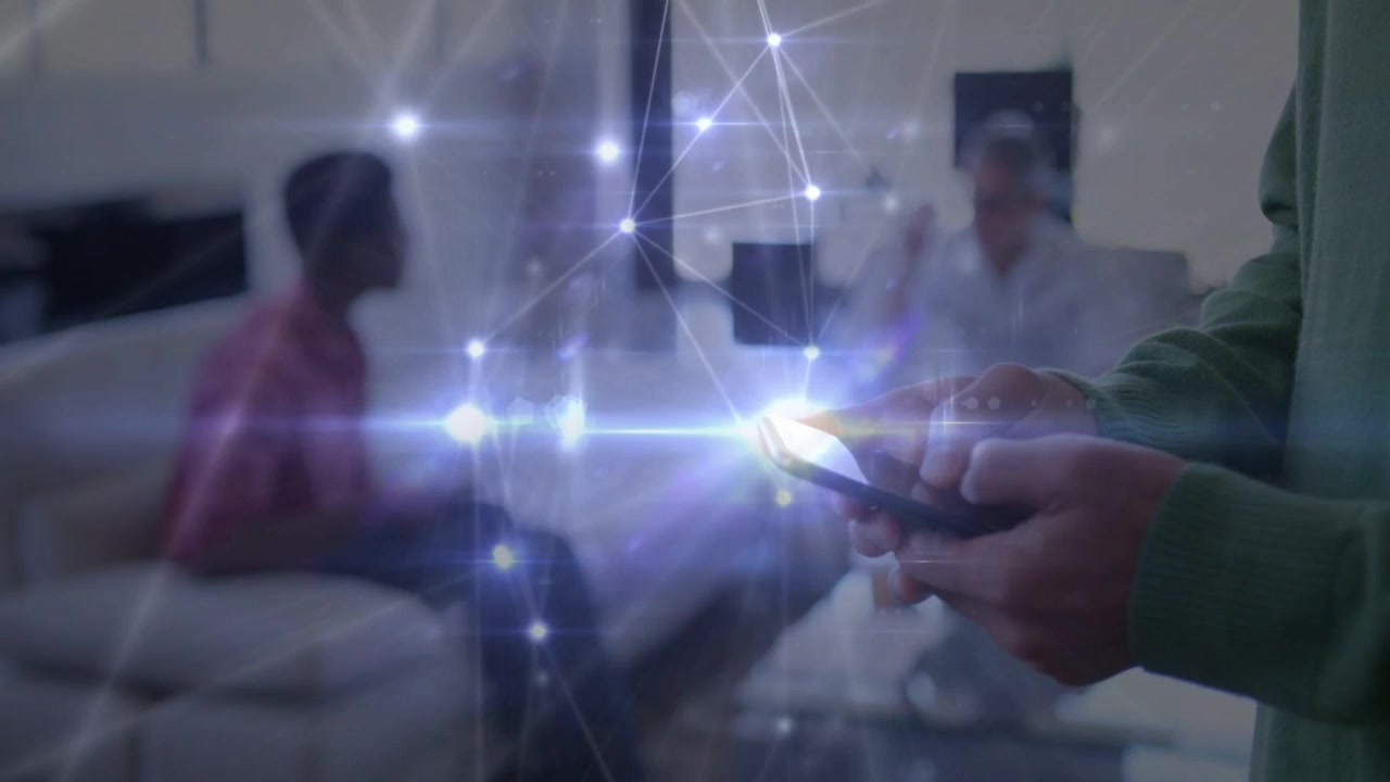 Foreground man tapping phone, scrolling, animating technology network to phone, engaging seated men