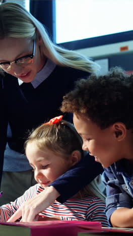 Animation-of-numbers-and-letters-over-smiling-caucasian-female-teacher-with-diverse-schoolchildren