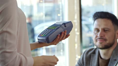 man paying with credit card in cafe