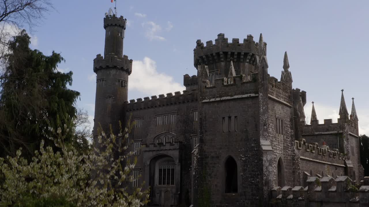el descenso aéreo del castillo de charleville captura su esencia gótica contra un cielo azul.