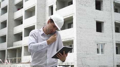ingeniero hombre con tableta hablando en teléfono móvil y comprobando el proceso de tecnología de construcción