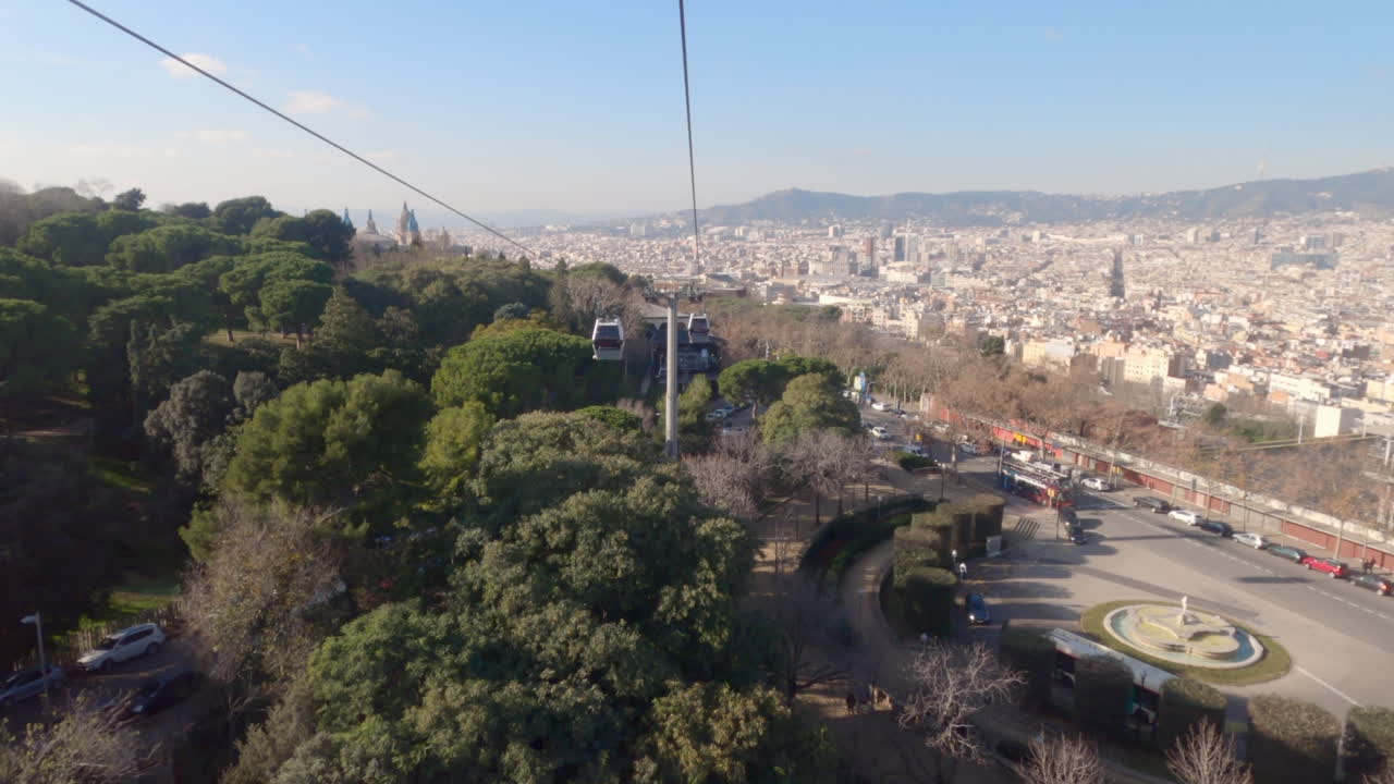 Cable car cabin POV, descending with a panoramic view of Barcelona
