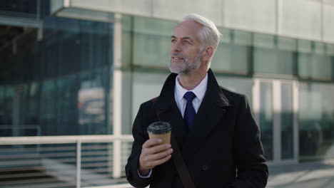 portrait of mature ceo businessman looking at watch impressed holding coffee