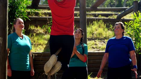 Women-applauding-female-trainer-while-rope-climbing