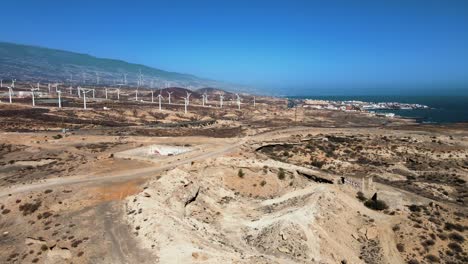 amplia toma aérea del vasto desierto con molinos de viento corriendo en el fondo, españa