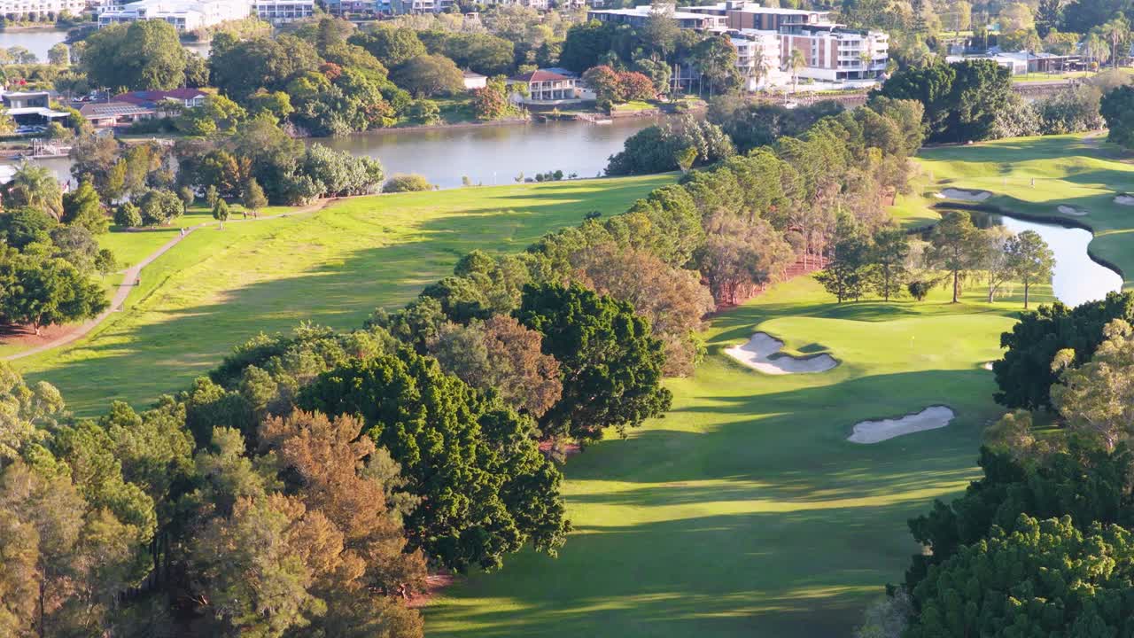 Drone footage captures a serene golf course in Gold Coast, Australia, with lush greenery and vibrant lighting