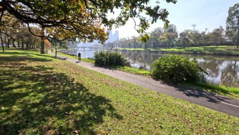 cyclist riding along scenic river path