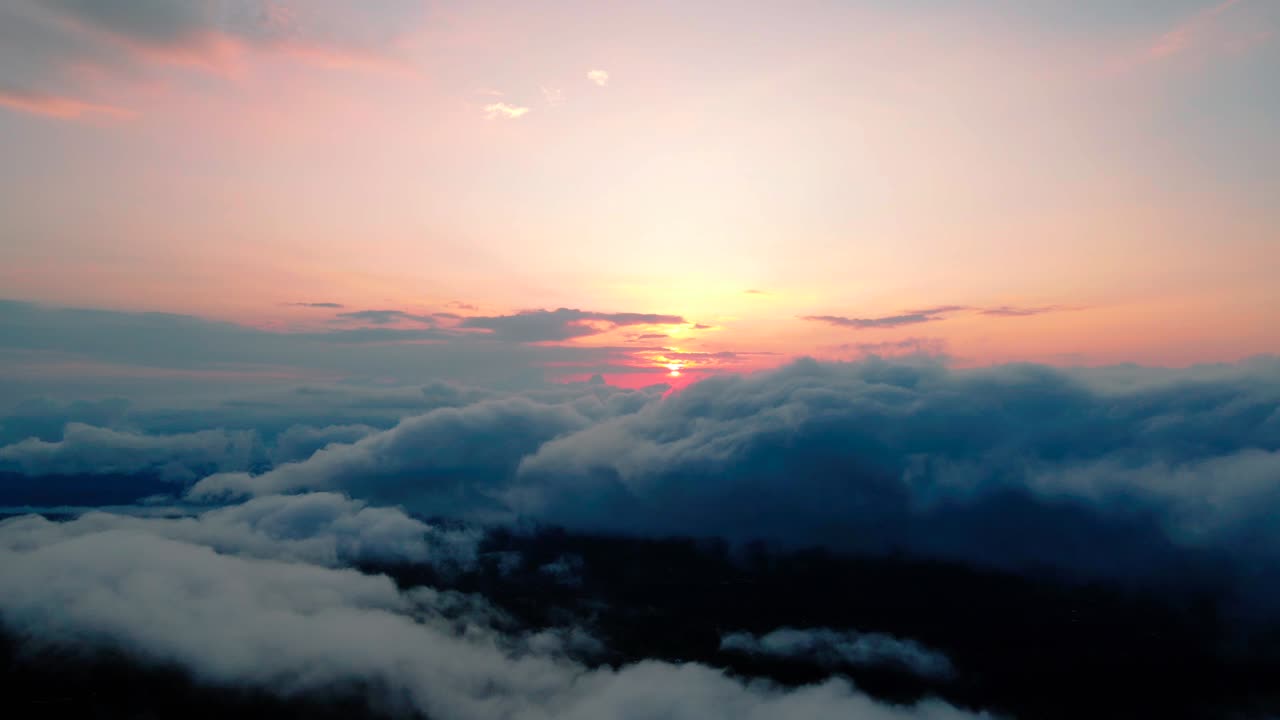 Veduta aerea del sole che sorge sopra le nuvole.