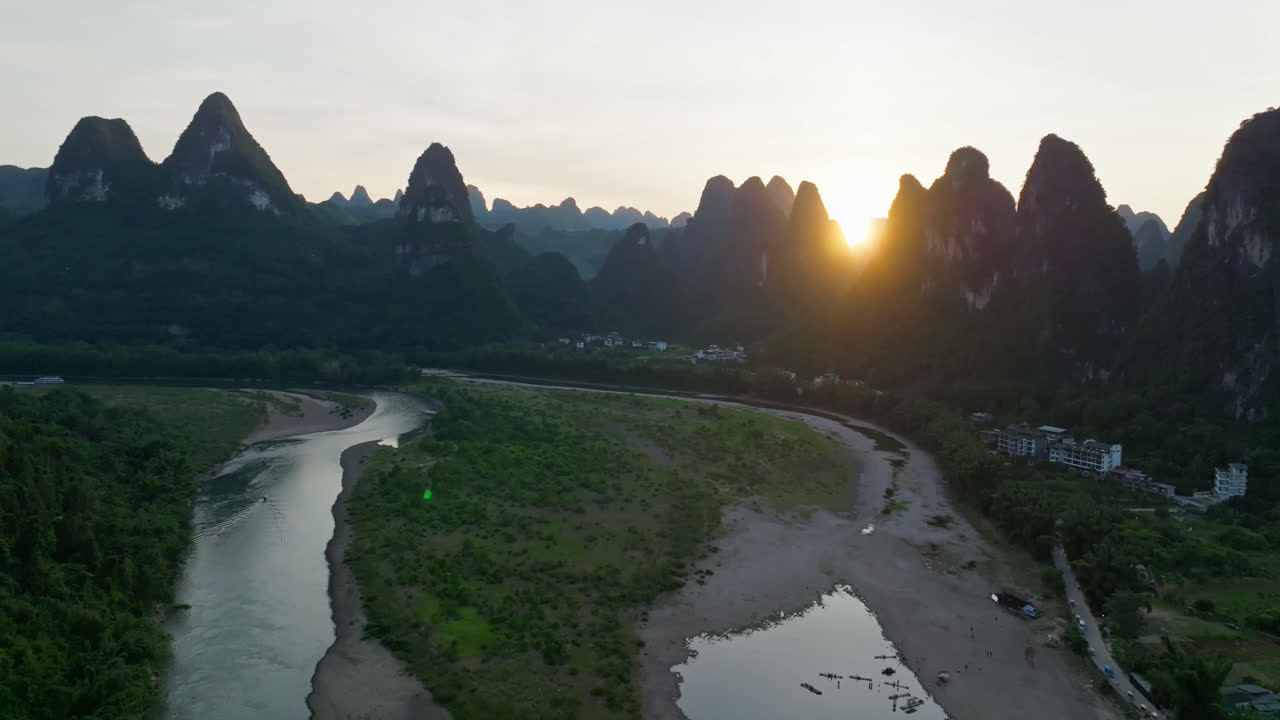 Aerial view close to a mountain wall, sunset above Li river and peaks of China