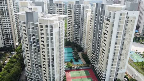 Modernos-Edificios-De-Apartamentos-De-Color-Blanco-Y-Gris-Alrededor-De-Piscinas-Y-Canchas-De-Tenis,-En-El-Centro-Urbano