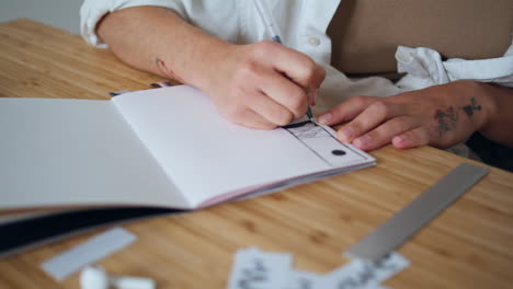 artist hands creating sketch home close up. designer fingers holding pen drawing