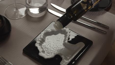 the waiter pours olive oil for testing