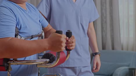 close up side view of asian male nurse  helping a patient to walk by walker during a physical therapy at home