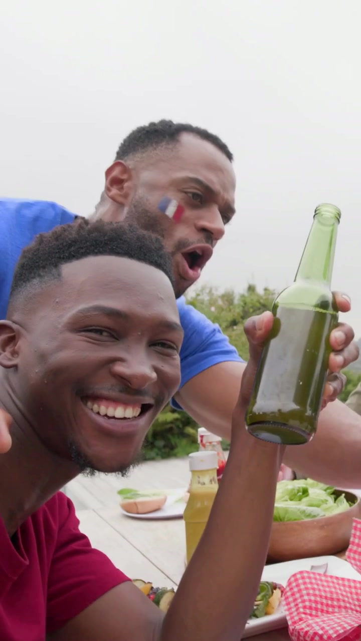 Verticale video: Filmt rode T-shirt wijzend naar blauw shirt dat groene fles vasthoudt poserend bij zwembad, ruimte voor tekst