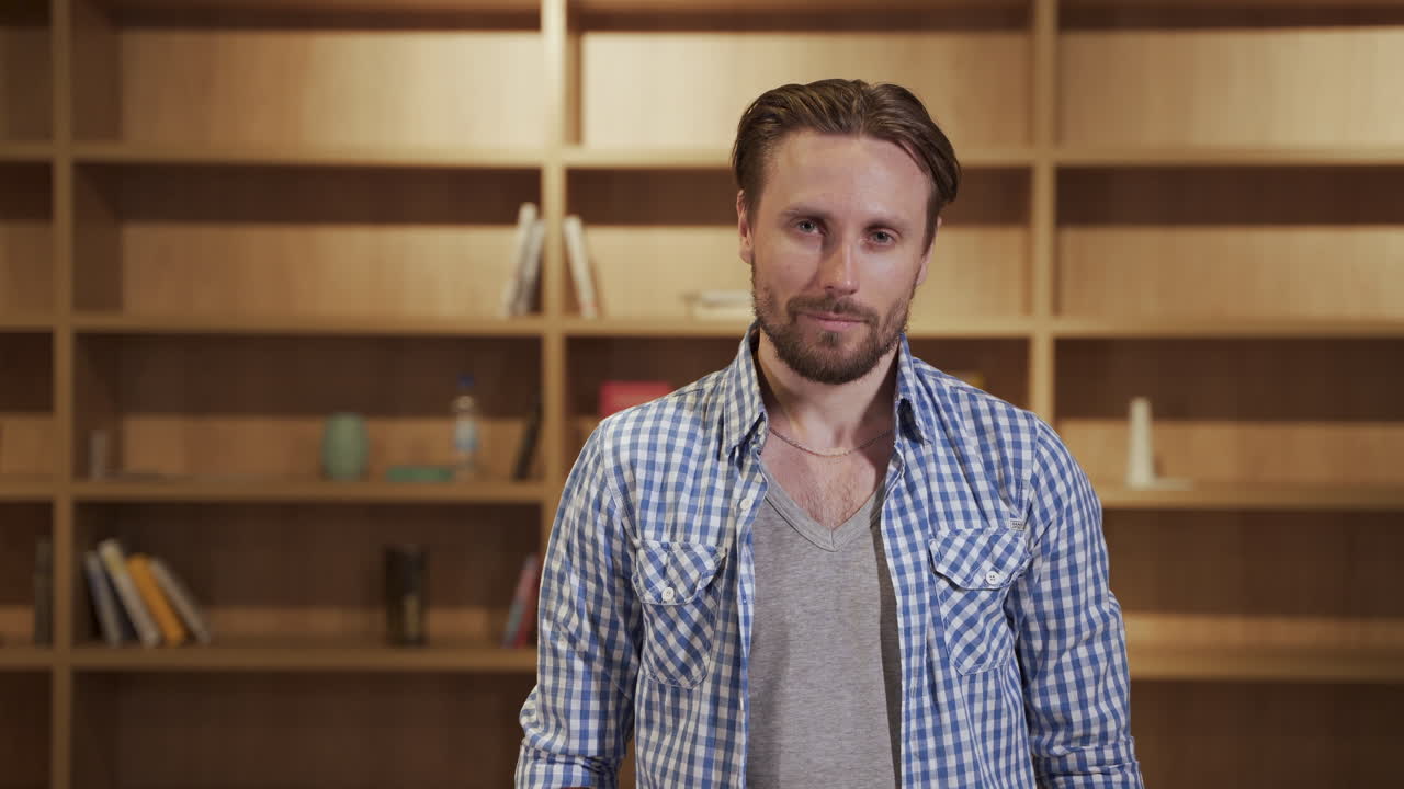 A handsome bearded man looks directly into the camera