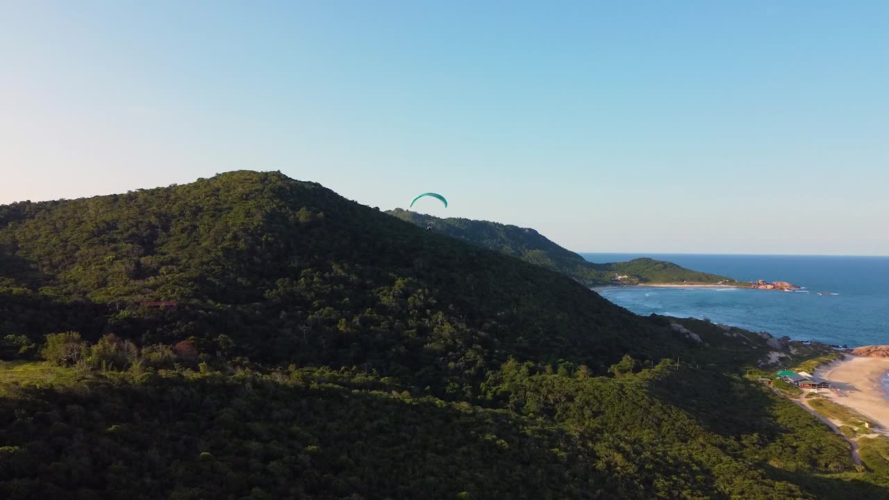 Flying paraglider over tropical island on the shore