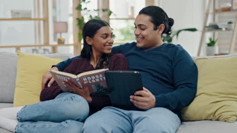 couple, tablet and reading a book on a home sofa