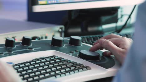 científico que opera un panel de control del microscopio