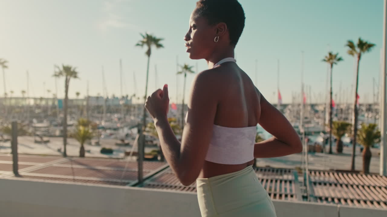 Giovane donna afroamericana che fa jogging lungo il lungomare
