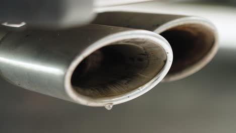 close-up of a v8 double exhaust with water vapor droplets bursting out. powerful cinematic shot emphasizing engine force and motion.