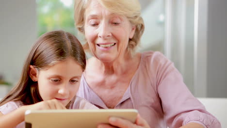 kind benutzt tablet mit ihrer großmutter