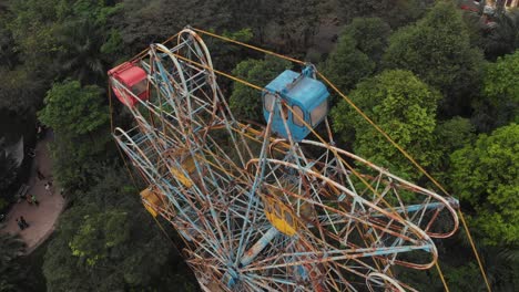 Flying-above-abandoned-ferris-wheel-at-Hanoi-Vietnam,-aerial