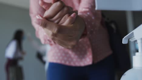 sección media de la mujer desinfectando sus manos