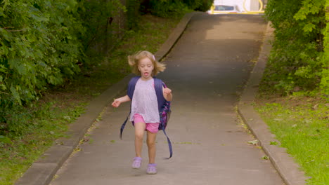 excited little girl running home from school with her backpack on