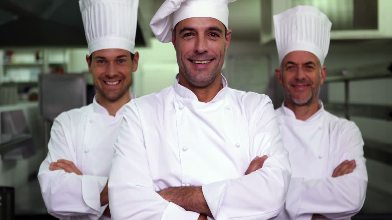 tres cocineros sonrientes mirando a la cámara haciendo una señal de ok