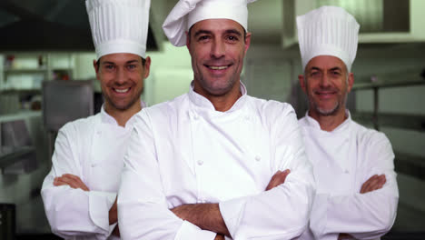 three smiling chefs looking at camera making ok sign