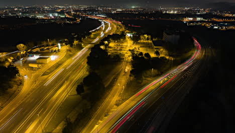 Zeitraffer-Luftaufnahme,-Beleuchteter-Verkehr,-Scheinwerfer,-Hauptverkehrszeit,-Nächtliches-Fahren-Auf-Der-Belebten-Autobahn-In-Der-Innenstadt