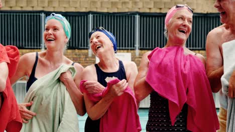 senioren, die nach dem schwimmen ihren körper mit handtüchern abwischen