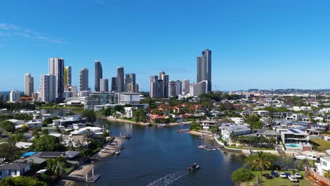 drone footage captures gold coast's skyline and waterways under clear blue skies, showcasing urban and natural beauty