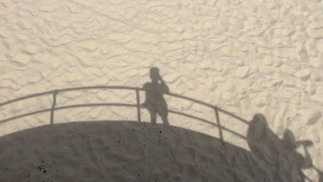 sombra de personas en la arena en un día soleado en la playa de bondi, australia