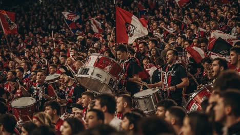 an electrifying atmosphere: passionate fans create a sea of red and black with drums and flags in an unforgettable sporting event