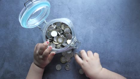 child saving money in a glass jar