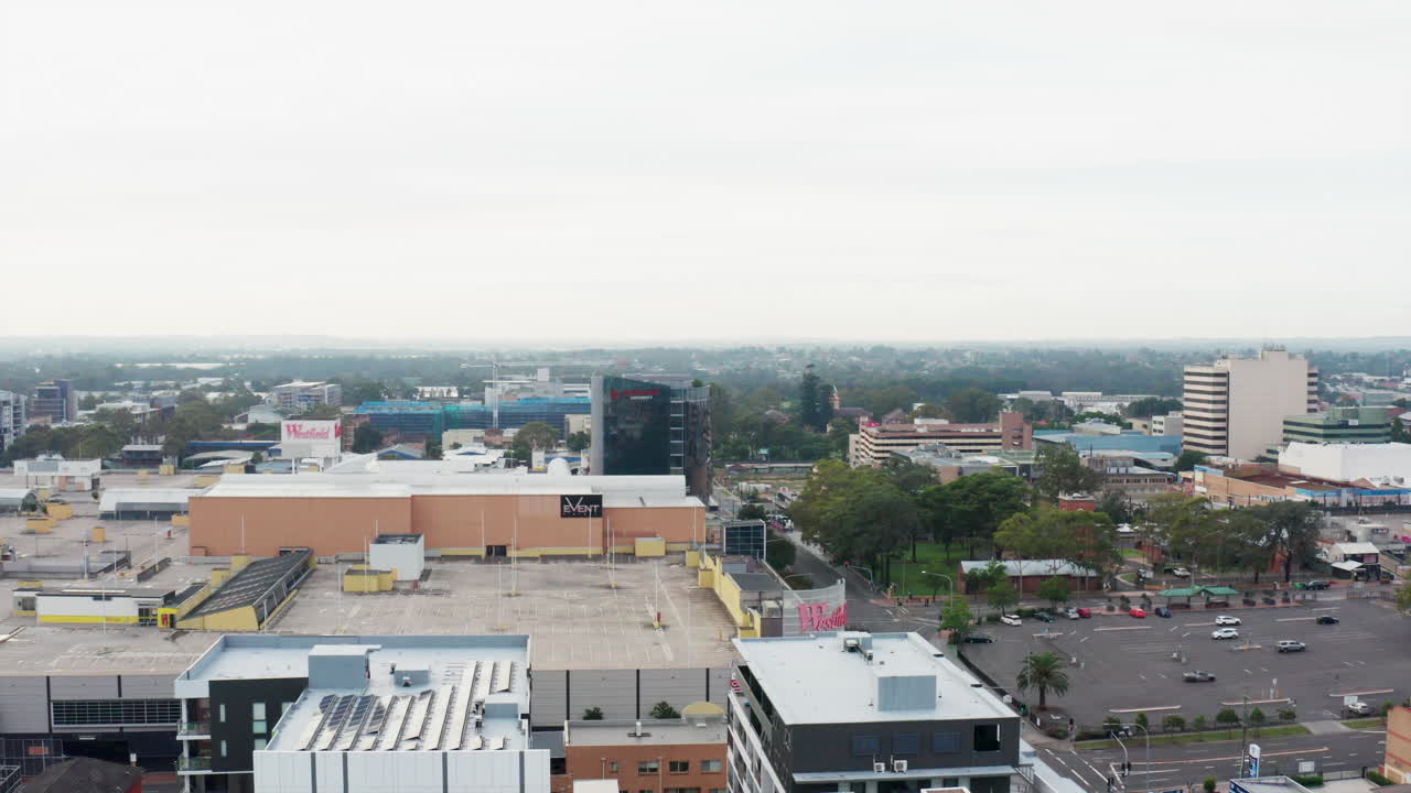 Aerial drone shot sliding left to reveal a construction crane in Liverpool city centre, Sydney, Australia