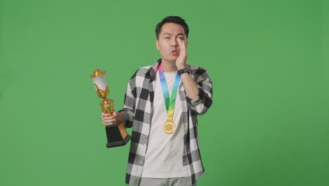 hombre celebrando una victoria con trofeo y medalla
