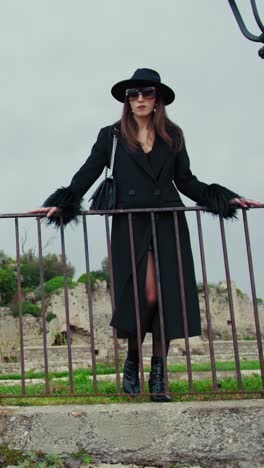 elegant model posing on the railing in the medieval italian town square